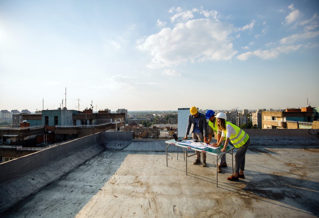 Team of architects and engineers people in group on construciton site check documents